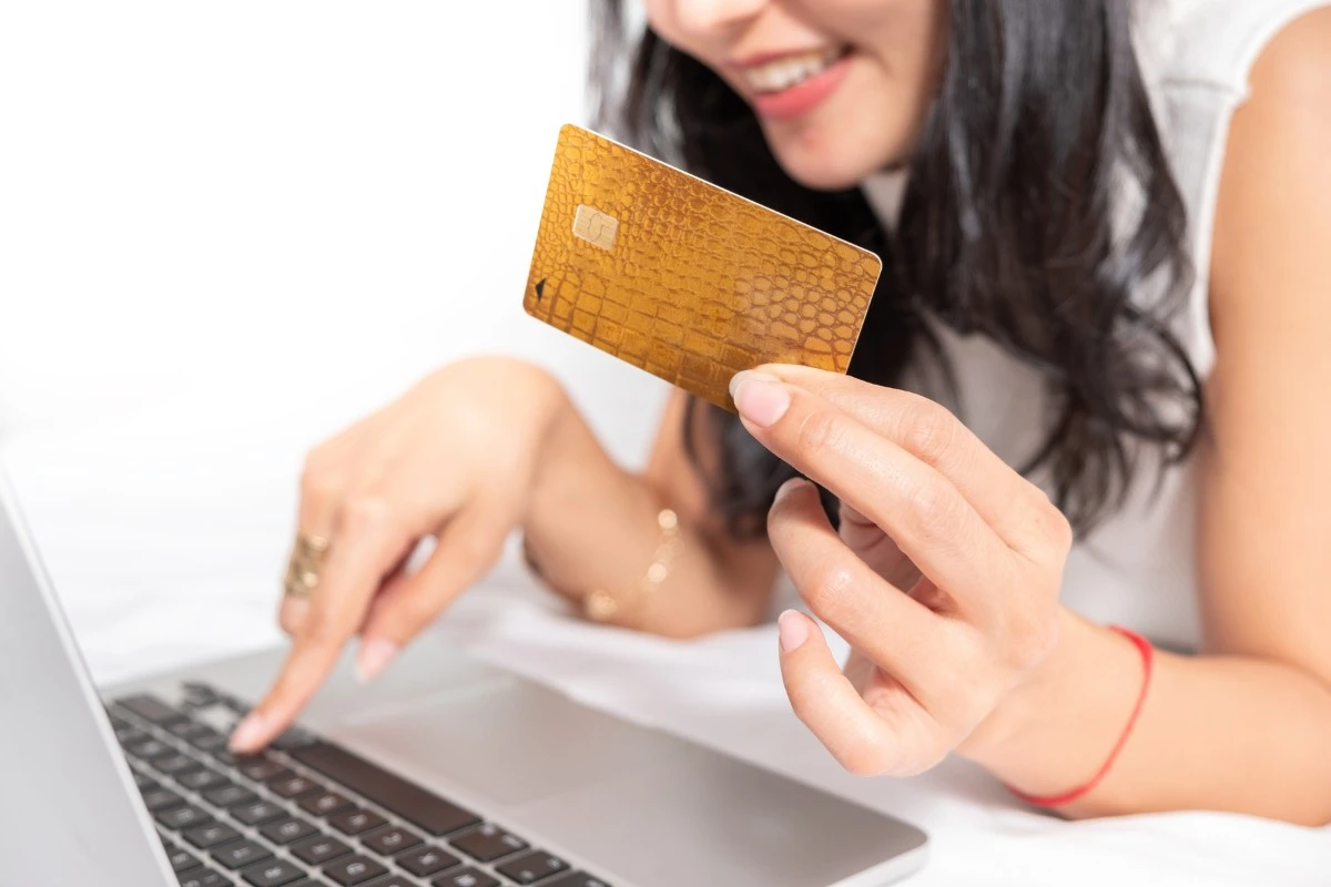Kvinna handlar online med kreditkort och laptop